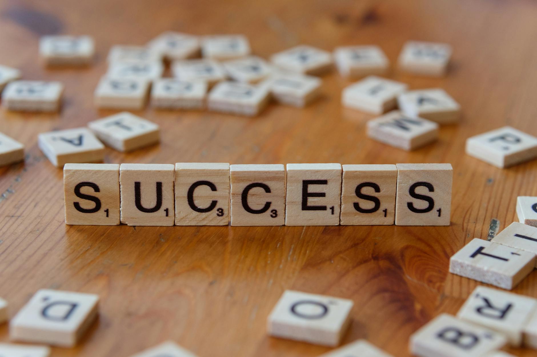 success concept with letter tiles on wooden surface